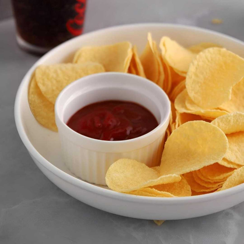 Bowl of potato chips with a small bowl of ketchup on a gray surface available at cupindy.com