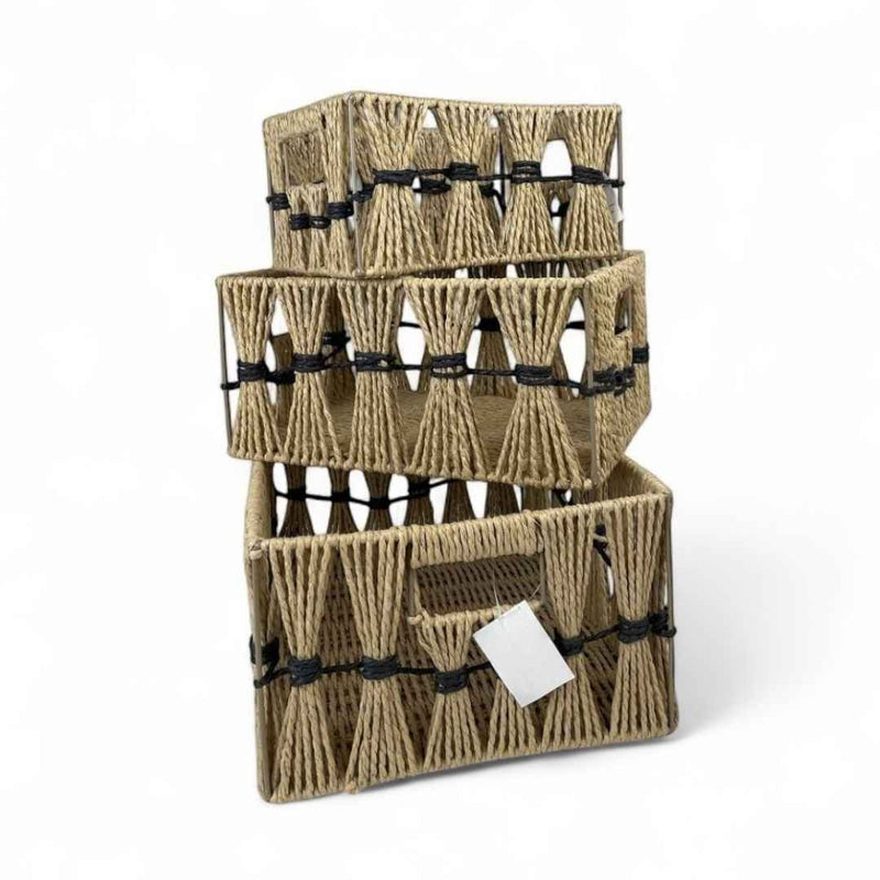 Stack of woven baskets with black straps on a white background