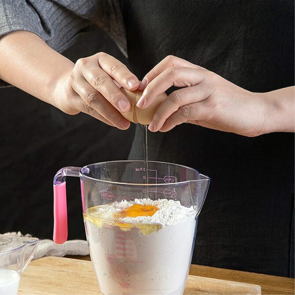 Woman Cracking Egg into Measuring Cup with Handle