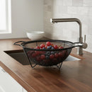 Black colander with grapes on a kitchen counter