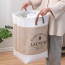 Person holding a beige and white laundry basket with 'Laundry Deluxe' branding.