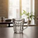Clear glass mug on a wooden table with a blurred indoor background