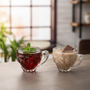 Two glass mugs with a red beverage and a creamy brown drink on a wooden surface.