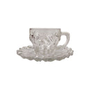 Clear glass teacup and saucer set on a white background