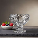 Clear glass bowl with intricate design on a dark surface with a blurred background