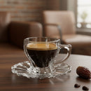 Clear glass cup with espresso on a wooden table with blurred background