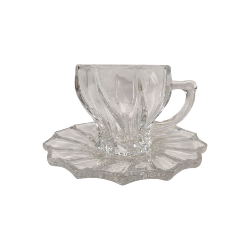 Clear glass teacup and saucer set on a white background