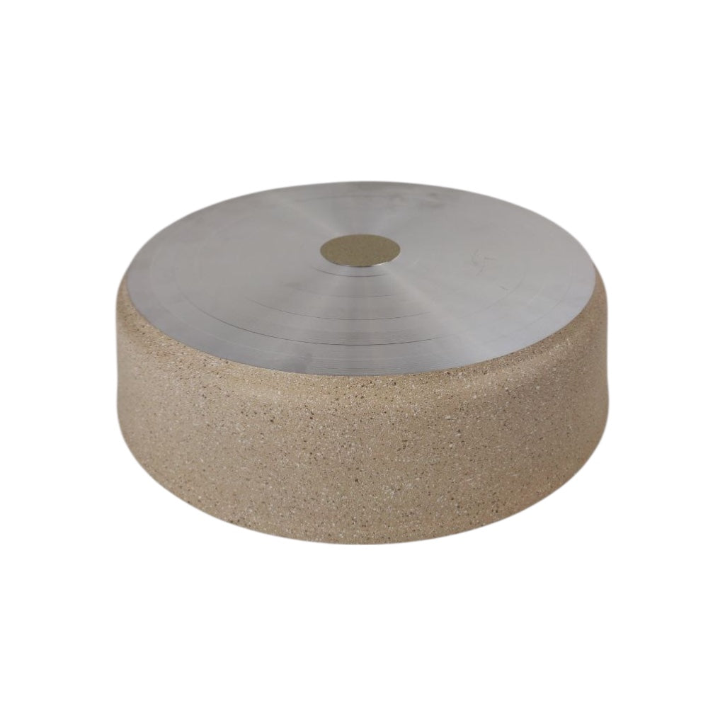 Round stone table with metallic top on a white background