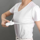 Woman measuring chest with retractable body tape for fitness tracking