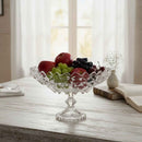 Clear glass fruit bowl with fruits on a wooden table