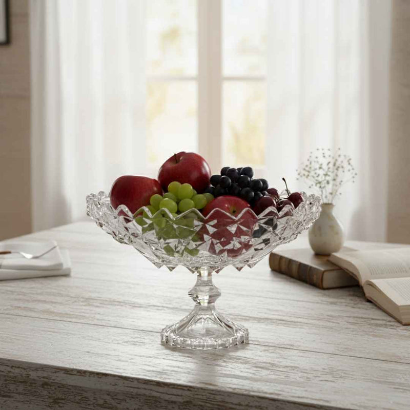 Clear glass fruit bowl with fruits on a wooden table