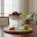 Fruit bowl with grapes, kiwis, and apples on a wooden tray in a dining room.