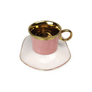 Pink teacup with gold interior and handle on a white saucer