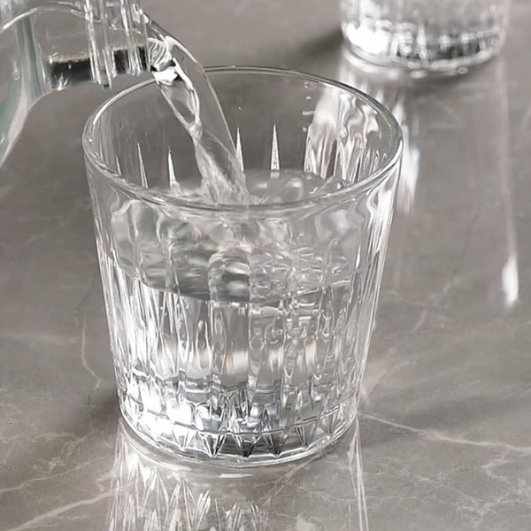 Pasabahce Luzia 300ml Glass Tumbler With Geometric Texture While Pouring Water On Marble Surface