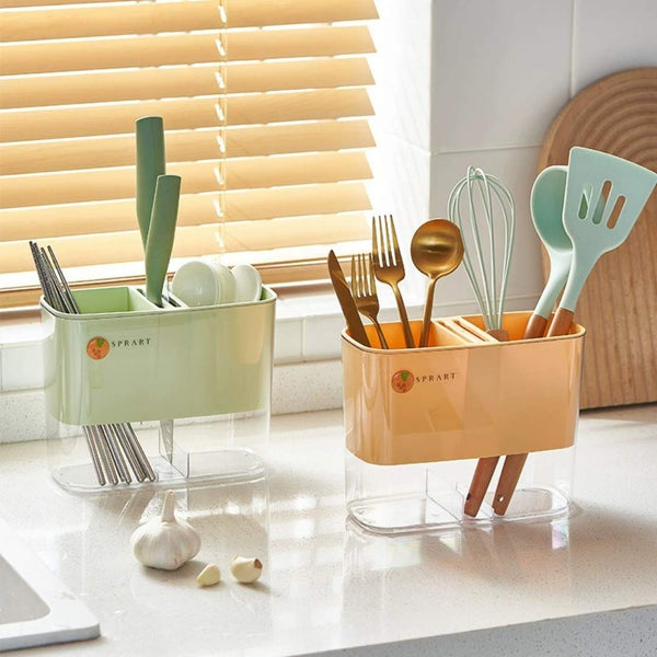 Two kitchen utensil holders on a countertop with utensils inside, in front of a window with blinds.