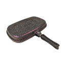 Griddle pan with speckled surface and black handle on a white background