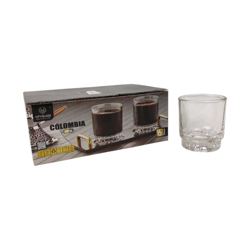 Clear glass tumbler next to its packaging on a white background
