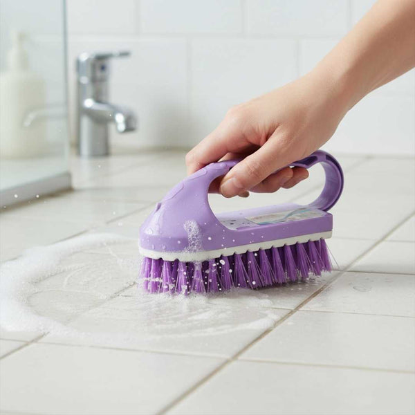 Purple scrub brush being used on a tiled bathroom floor.