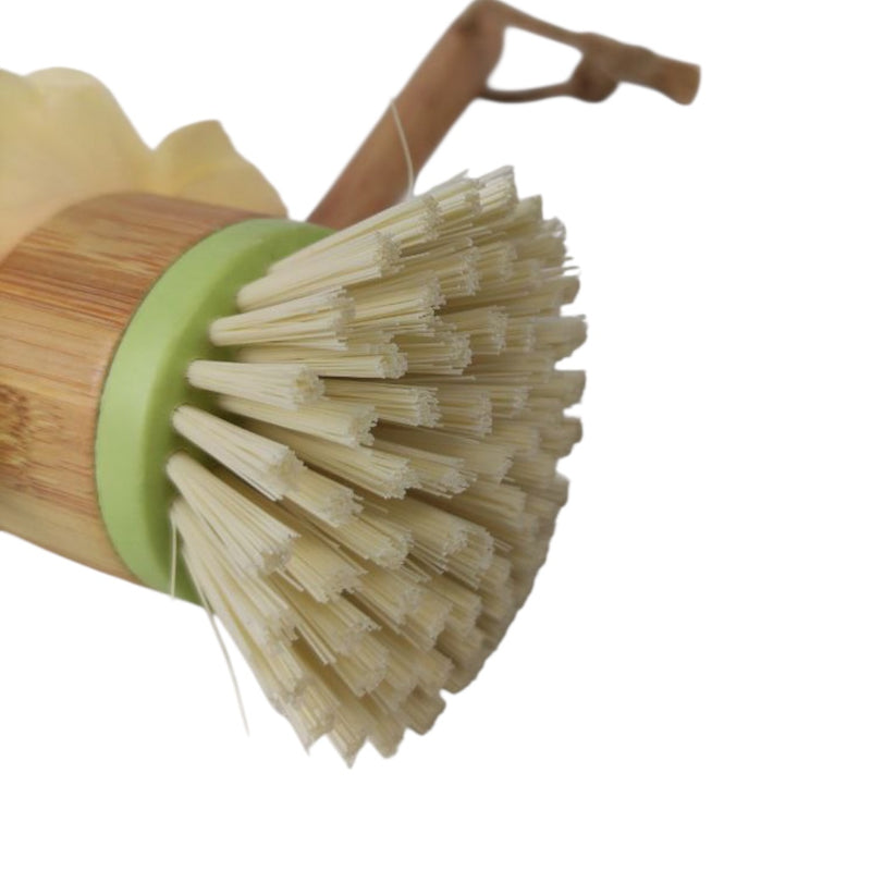 Bamboo dish brush with a green handle on a white background