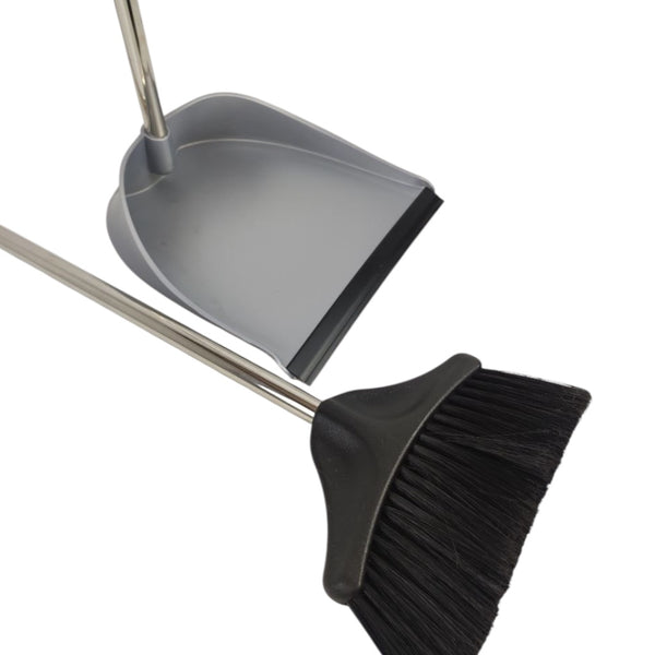 Gray dustpan and black broom with metal handles on a white background