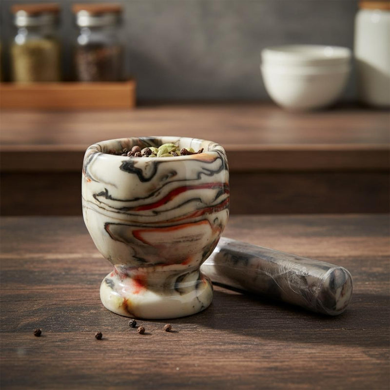 Marble-patterned mortar and pestle on a wooden surface with spices in the background