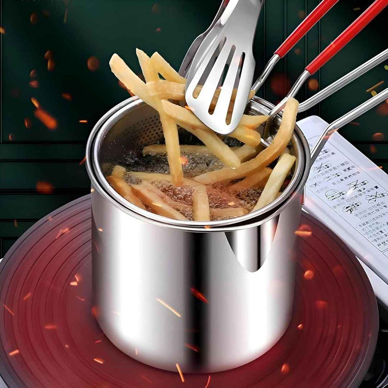 Stainless steel pot with french fries being fried on a stovetop.