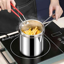 Stainless steel pot with strainer on a induction cooktop, filled with hot oil and frying chips.