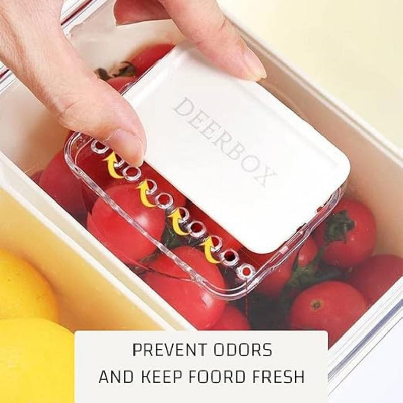 Hand placing a 'Deerbox' product into a container with tomatoes, promoting odor prevention and freshness.