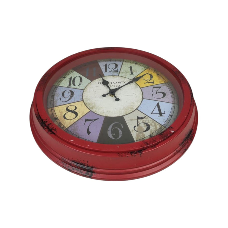 Round wall clock with a colorful face and red frame on a white background