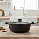 Black cast iron cookware on a wooden kitchen counter with a blurred background