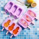 Purple silicone ice pop molds with shaped cavities on a blue tiled background.