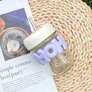 Small glass cup with handle-style letter wrap and straw