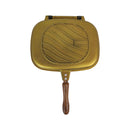 Gold-colored grill pan with wooden handle on a white background