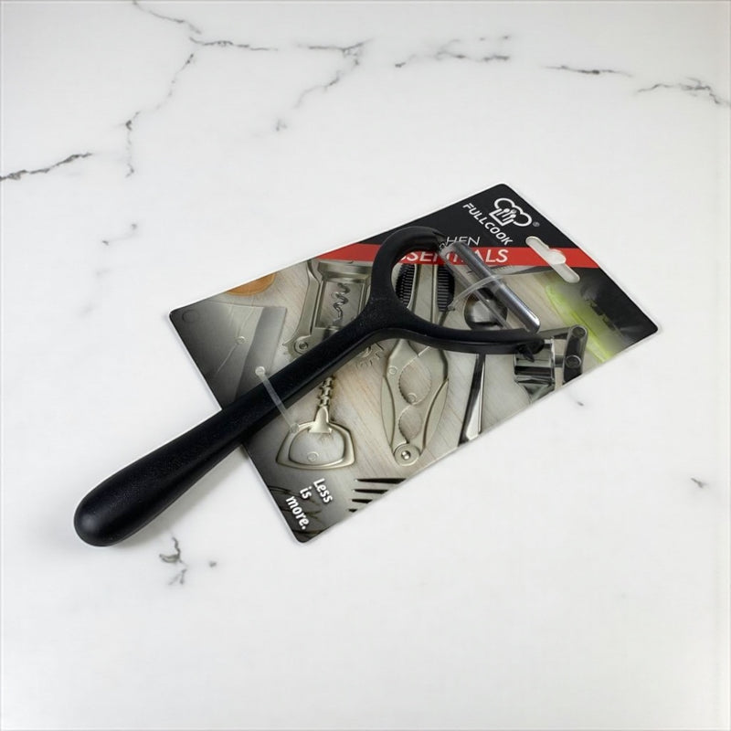 Black kitchen tool on a white marble surface with packaging in the background