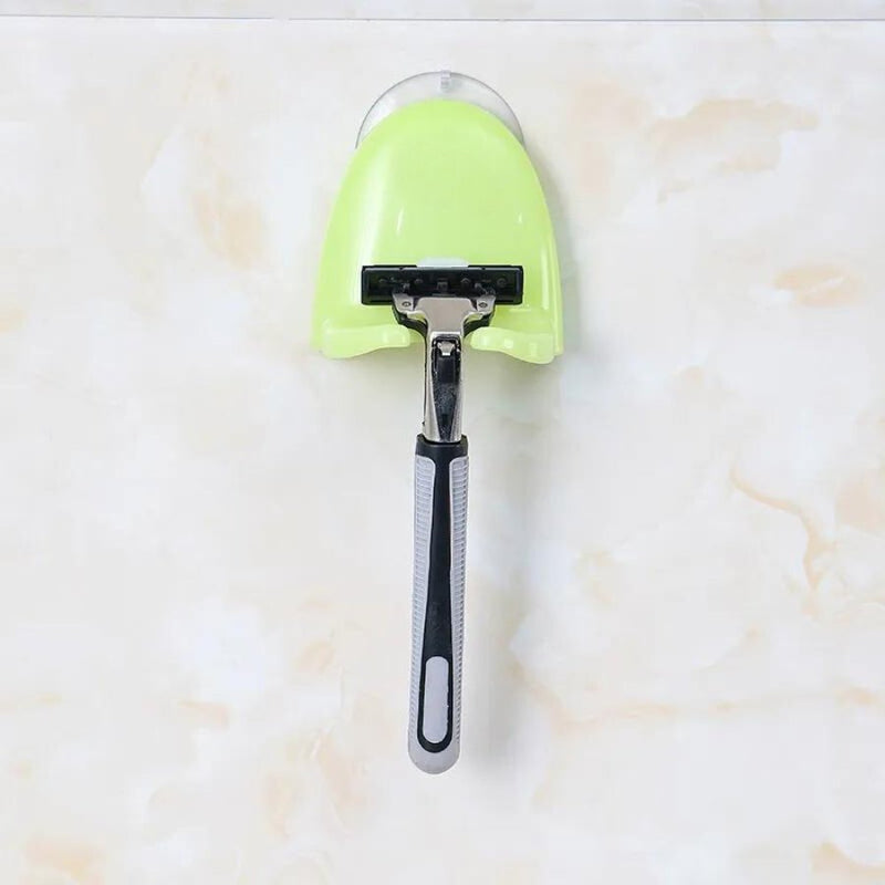 Green suction cup holder for razors in a bathroom setting.
